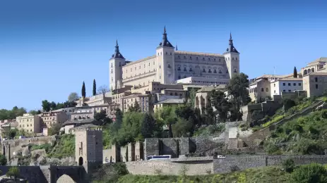 View of Alcazar Fortress surrounded by vegetation in Toledo, Spain