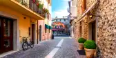 Narrow street in the old town of Bardolino with pebblestone pavements on a sunny day 