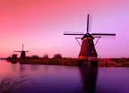 A pink sunset over the Lek River and Kinderdijk windmill monuments, South Holland, Netherlands