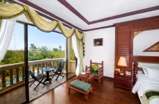 Luxurious hotel room with large patio doors open to a balcony 