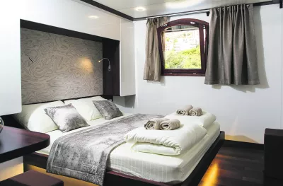 Interior of double bedroom with small window aboard the MV Corona ship
