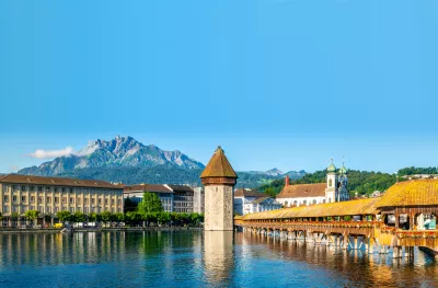 Scenic panoramic view of Lucerne, Switzerland with Chapel bridge or Kapellbrucke and Pilatus mount with clear blue sky during summer