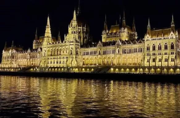 Parliament building at night overlooking the Danube river in Budapest, Hungary