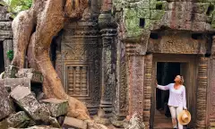 Image of a woman looking up in the ruins of an ancient temple in the rainforest