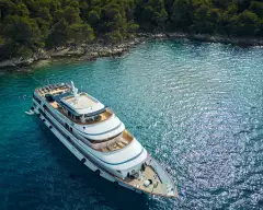 Square image of yacht ship anchored in crystal blue waters of a secluded bay
