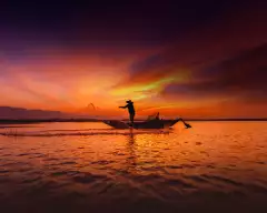 Silhouette of traditional fisherman throwing net fishing inle lake at sunrise time, Myanmar