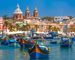 Traditional colourful eyed boats Luzzu at harbour in Marsaxlokk, Malta