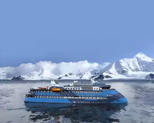 Exterior of the Ocean Albatros ship with snowy mountains in background