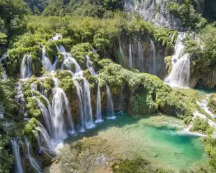 Croatia waterfalls with tourists overlooking the beautiful view from a nearby hanging bridge