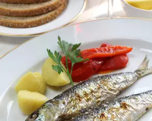 Charcoal grilled sardines with boiled potatoes and peppers with a side of red wine