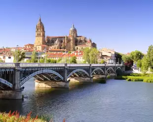 View of bridge across river in Spain with Salamanca cathedral in the background