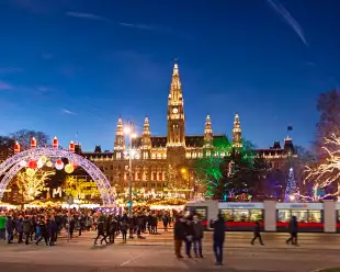 Christmas market with festive lights during the late evening in Rathausplatz square, Vienna, Austria