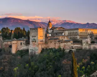 Arabic palace Alhambra with Sierra Nevada mountains in the background at twilight in Granda, Spain