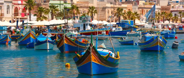Traditional colourful eyed boats Luzzu at harbour in Marsaxlokk, Malta