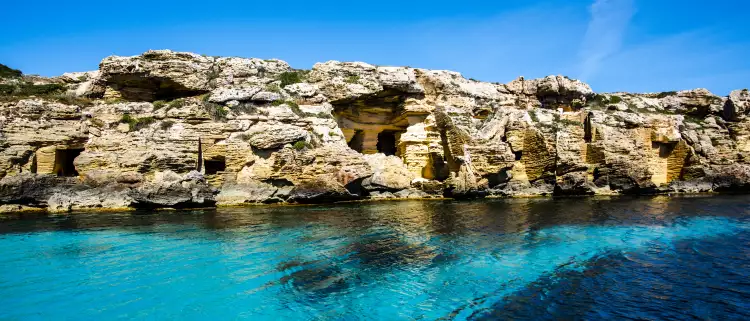 Shallow blue ocean with a background of coastal rocks 