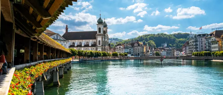 Jesuitenkirche Rathaussteg bridge over blue water with buildings in the background, Lucerne, Swizerland