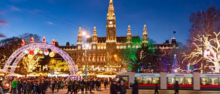 Christmas market with festive lights during the late evening in Rathausplatz square, Vienna, Austria