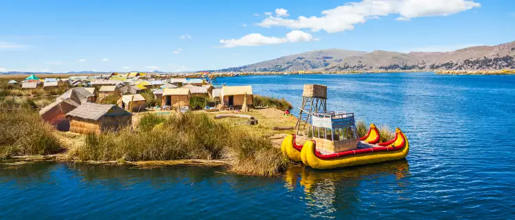 The floating islands on Titicaca Lake, featuring moored kayaks and wooden cabins